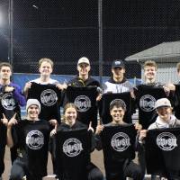 Students holding up championship shirts from a softball tournament